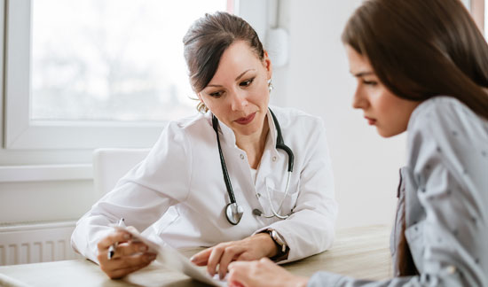 Physician helping young woman understand test results